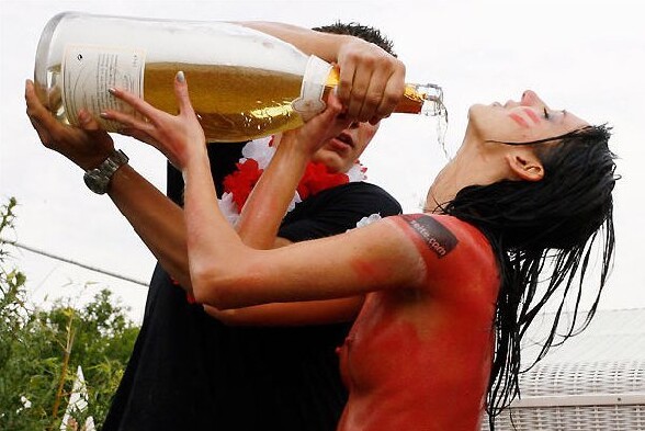 Petite douche au champagne pour cette brune topless bodypaintee - bodypainting une fille peinte en rouge qui fait de la pub pour un site internet se prend une douche au magnum de champagne